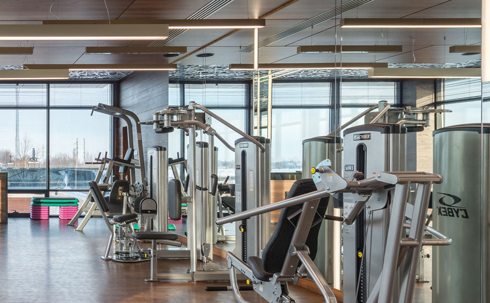 Bruchsichere Spiegelwand zum modernen Fitnessstudio, ideal für professionelle Trainingsräume mit hochwertigen Fitnessgeräten.